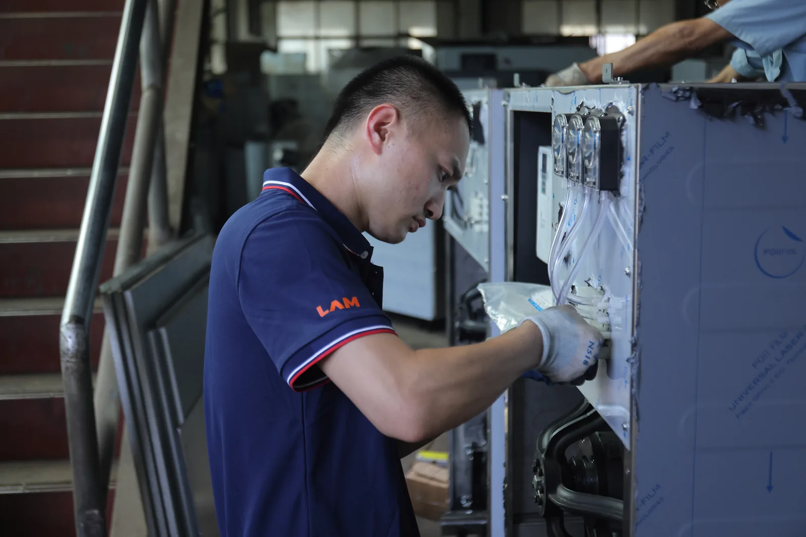 Laundry Aide technician assembling a commercial washer